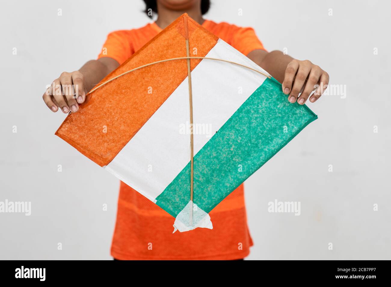 Young Indian boy holds onto a Kite with the tricolour of Indian flag