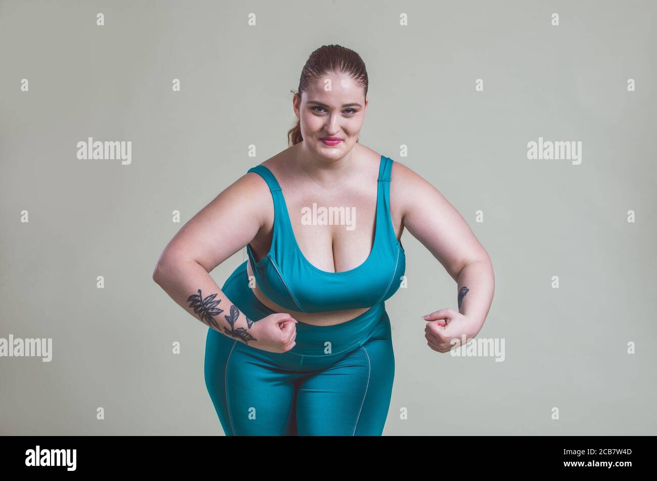 Plus size woman making sport and fitness. Studio portraits with