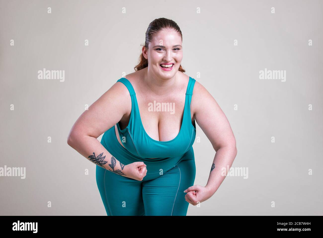 Plus size woman making sport and fitness. Studio portraits with