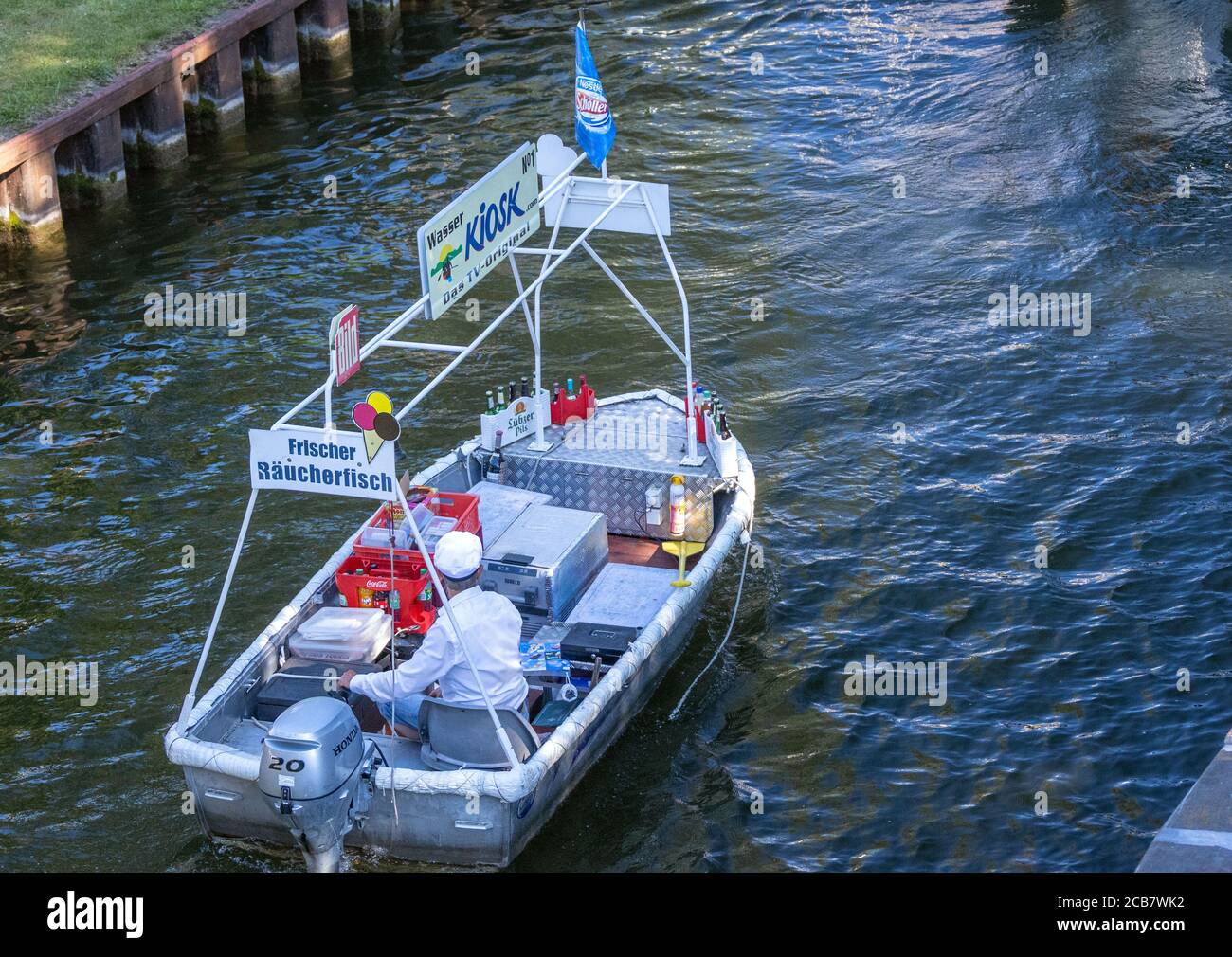 Canow, Germany. 06th Aug, 2020. Jens Winkelmann is on the move with his water kiosk on the Müritz-Havel Canal and supplies holidaymakers on houseboats, yachts and canoes with ice, cold drinks or freshly smoked fish. Every day during the season he is on the waterways and lakes at the state border of Brandenburg and Mecklenburg for up to 80 kilometres. The Brandenburg native has converted his four-metre-long, old barge into a kind of "floating consumption" with a freezer and and fresh-keeping boxes. Credit: Jens Büttner/dpa-Zentralbild/ZB/dpa/Alamy Live News Stock Photo