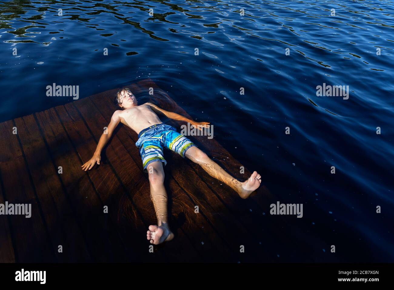 Boy floating with his eyes closed and arms and legs outstretched on lake Egelsee, Austria, Oberösterreich, Upper Austria Stock Photo
