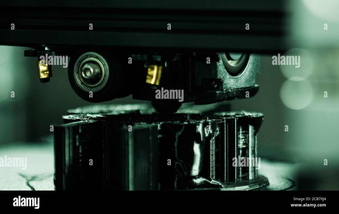 3D printer working in a factory printing plastic part. Stock Photo
