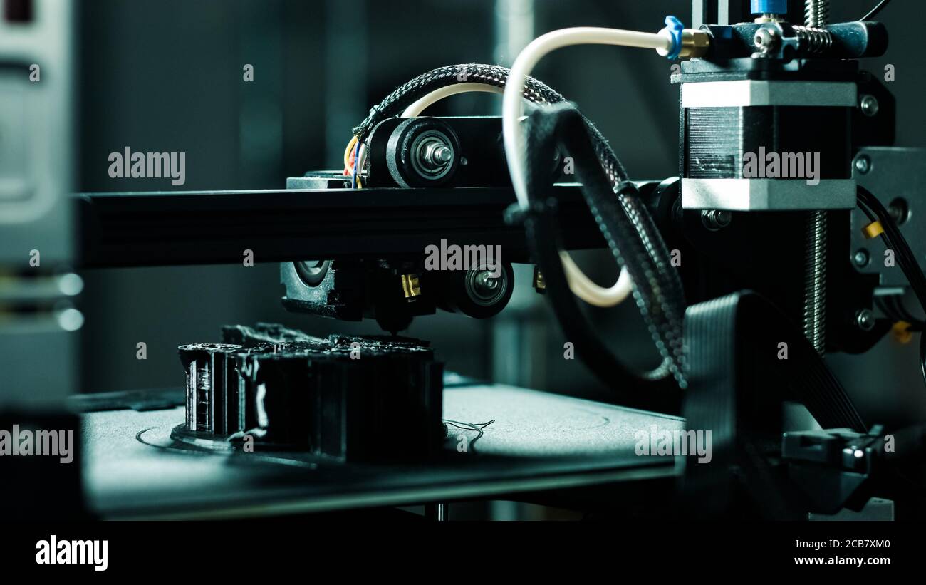 3D printer working in a factory printing plastic part. Stock Photo