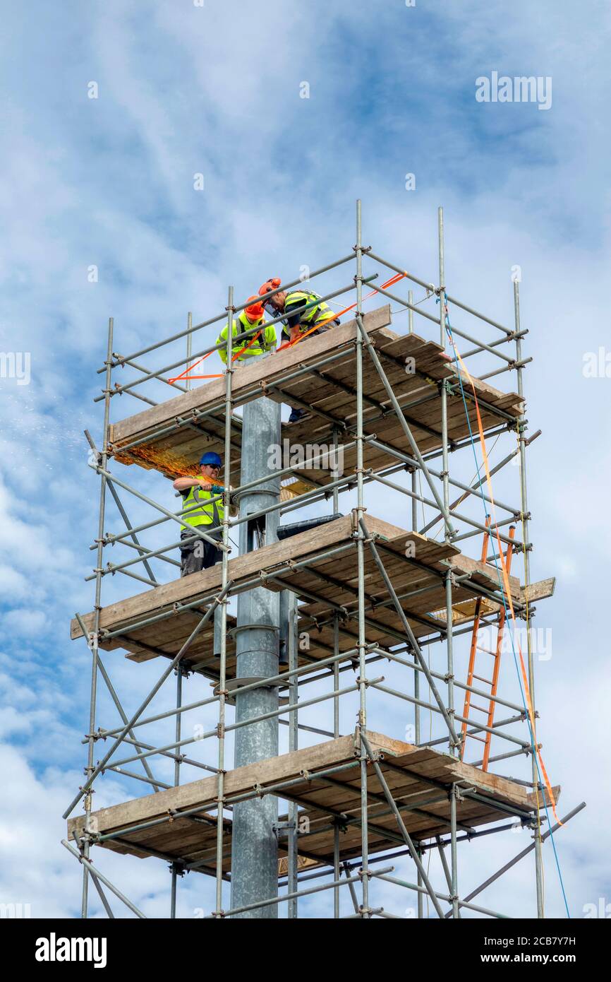 Scaffolding tower, workmen deconstructing. Stock Photo