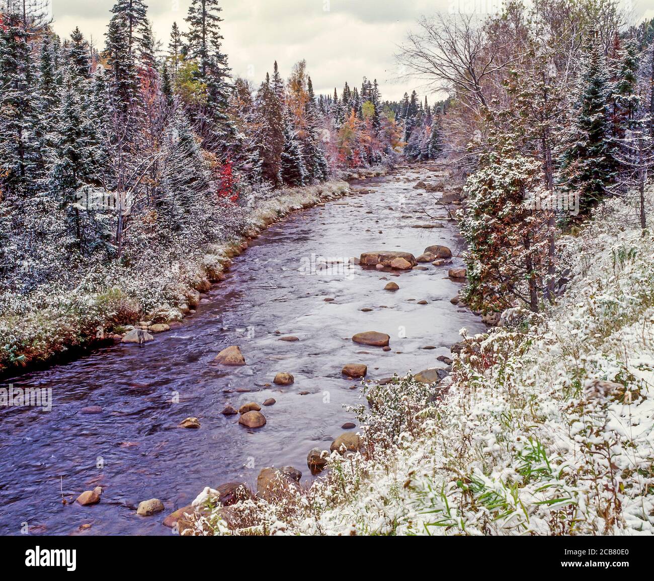 Early winter snow in fall colorful trees on the West Branch of the Ausable River in Lake Placid the Adirondack Mountains of New York State United St Stock Photo