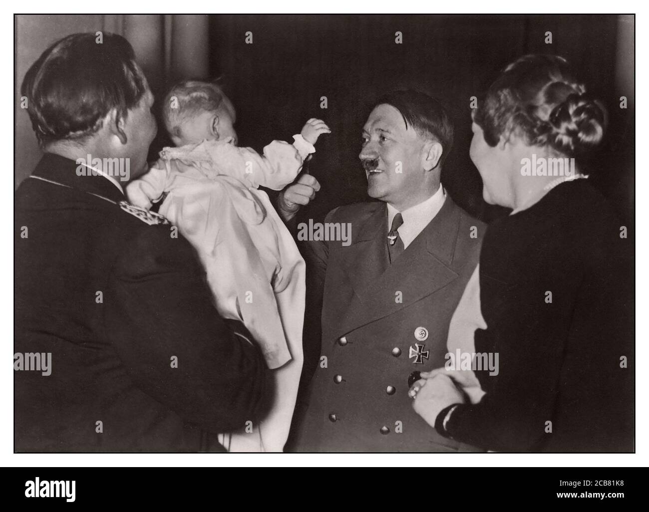 Vintage Nazi Propaganda 1939, The Leader [ Adolf Hitler] is with the Goering Family  'Der Führer im Kreis der Familie Göring', Propaganda Image showing Adolf Hitler as a caring family orientated man Stock Photo