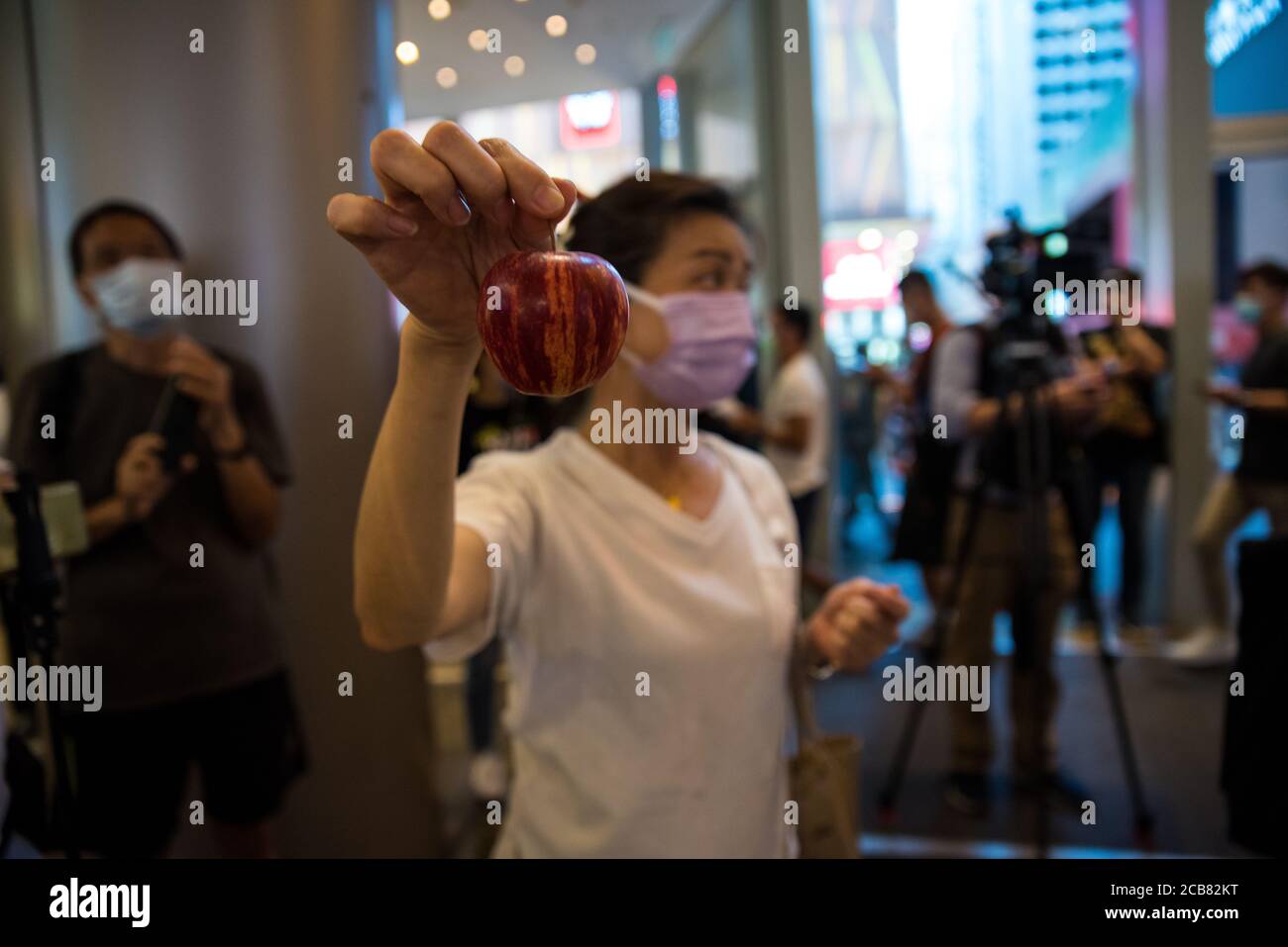 Hong Kong, China. 11th Aug, 2020. A protester holds an apple, as a reference to the newspaper 'Apple Daily', during a flashmob in the Langham Place mall, to support pro-democracy activists arrested under the national security law. Credit: Marc R. Fernandes/ Alamy live News Stock Photo
