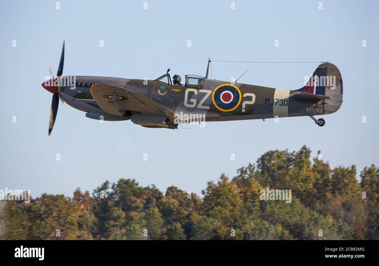 A British Spitfire fighter aircraft flies at treetop level during the