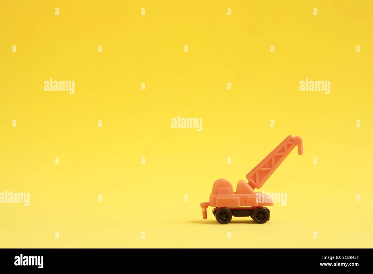 Plastic toy with crane shape in color background Stock Photo - Alamy