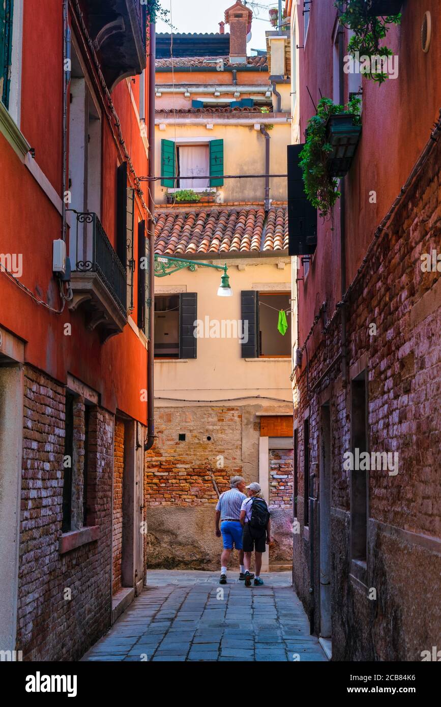 Woman walking through narrow street hi-res stock photography and images ...