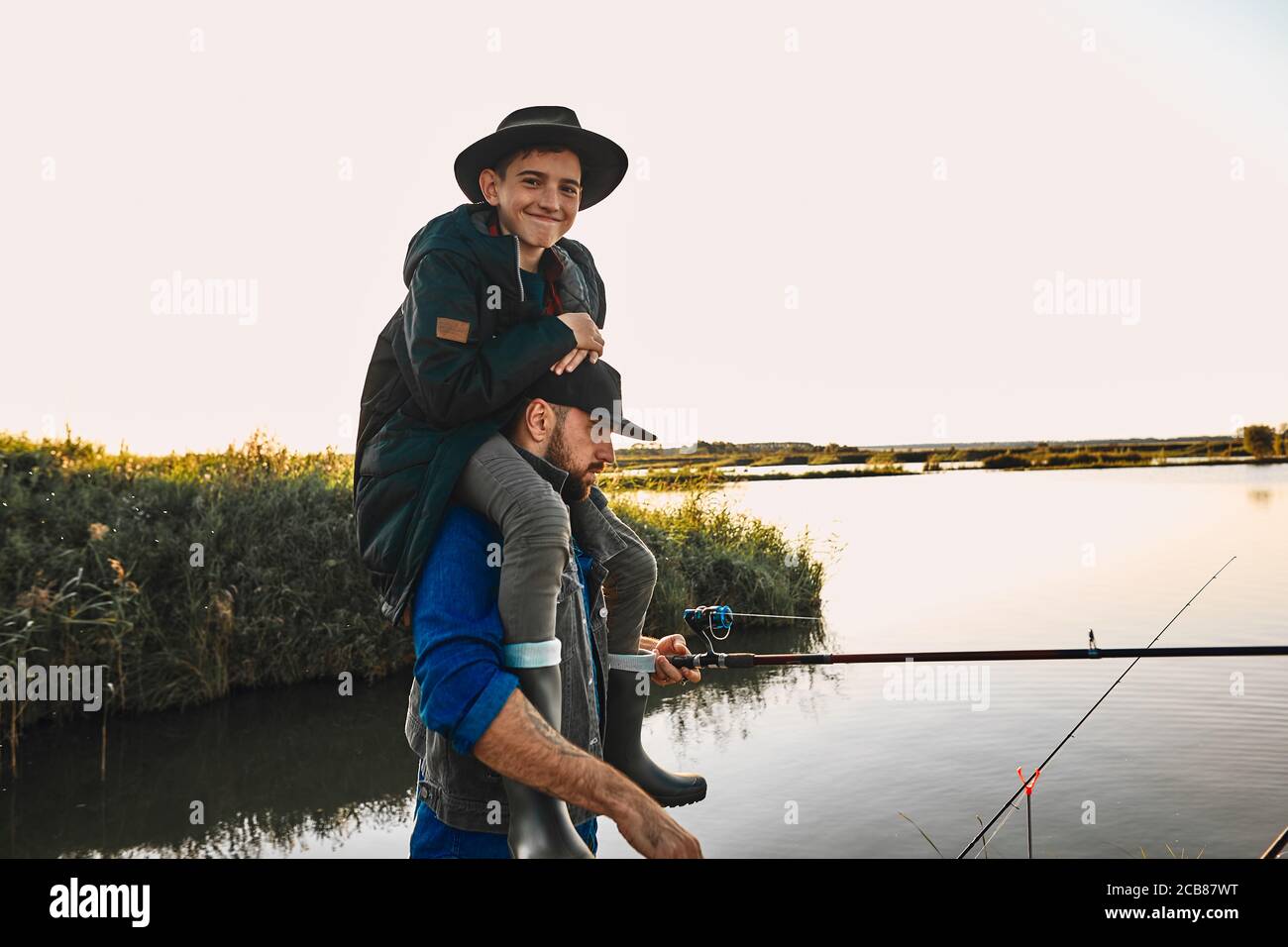 https://c8.alamy.com/comp/2CB87WT/father-and-son-have-fun-while-fishing-teen-boy-happy-and-smile-sit-on-father-shoulders-2CB87WT.jpg