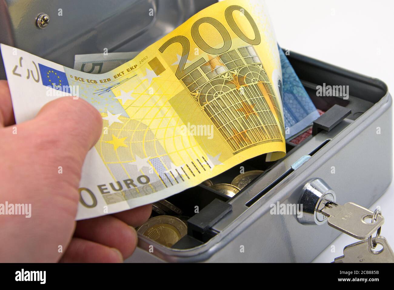 Hand reaches into a cash box with euro bills Stock Photo