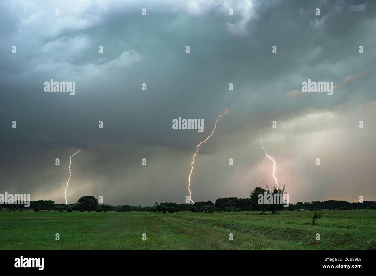 Several lightning bolts strike down from a severe thunderstorm in Hungary Stock Photo