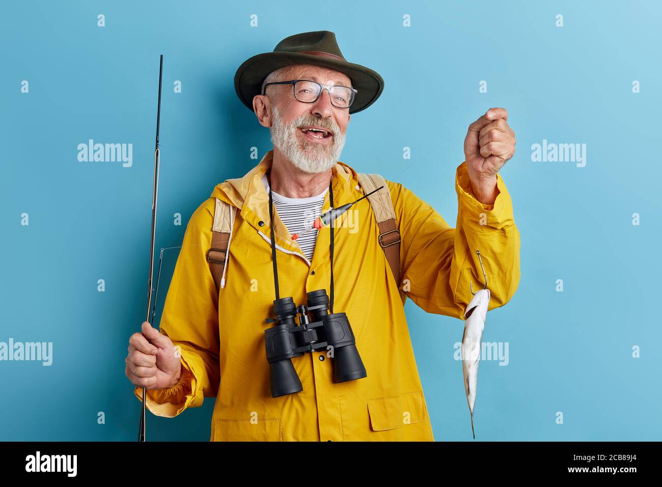 old granny in glasses having glad expression, close up photo. isolated blue background, studio shot Stock Photo