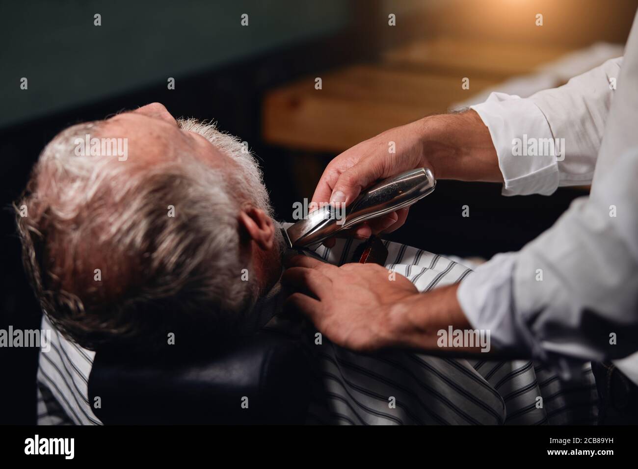 barber using electro shaver while working at beauty salon, close up ...