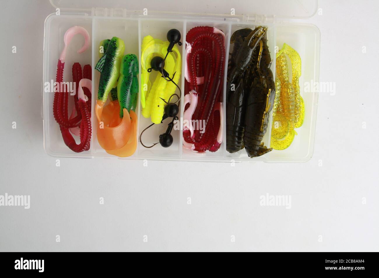 Overhead shot of colorful rubber worms fishing lures in a tackle box on  white background Stock Photo - Alamy