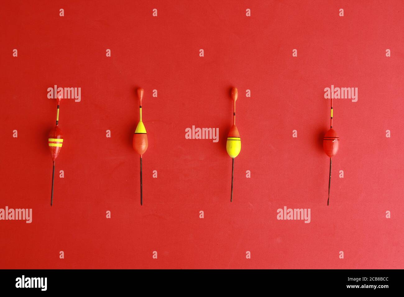 Top view of colorful fishing rod bobbers on a red background Stock Photo -  Alamy