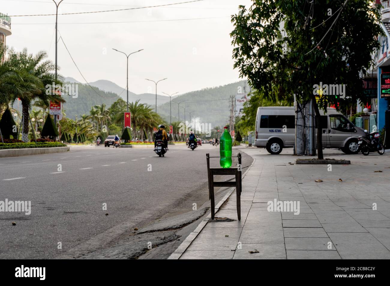 Petrol or gasoline for sale on the street in reused plastic bottle. Plastic bottle with gasoline stay on the stool on the sidewalk near the store. Stock Photo