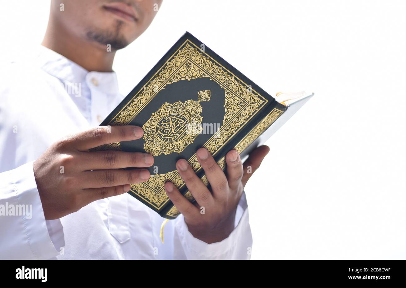Holy Quran In Hand With Arabic Calligraphy Meaning Of Al Quran Stock Photo Alamy