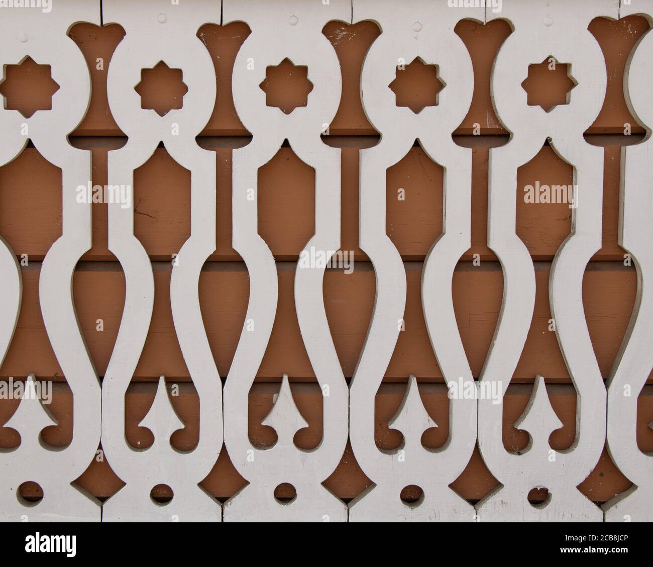 Flat carved white balusters made of wood on a dark background. East Siberian ornament, Russia. Stock Photo