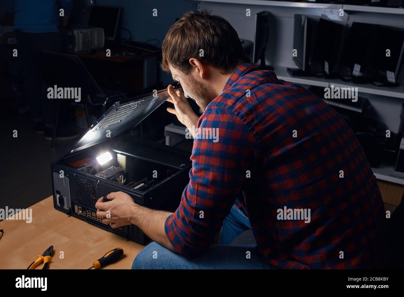 awesome happy man enjoying working with broken computers, favourite job. man has found the reason of broken PC Stock Photo