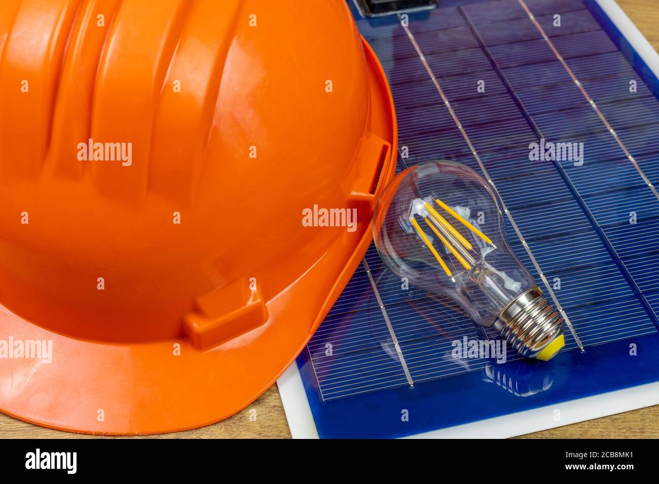 Pv Module Bulb photovoltaic panel with led bulb and orange helmet Stock Photo - Alamy