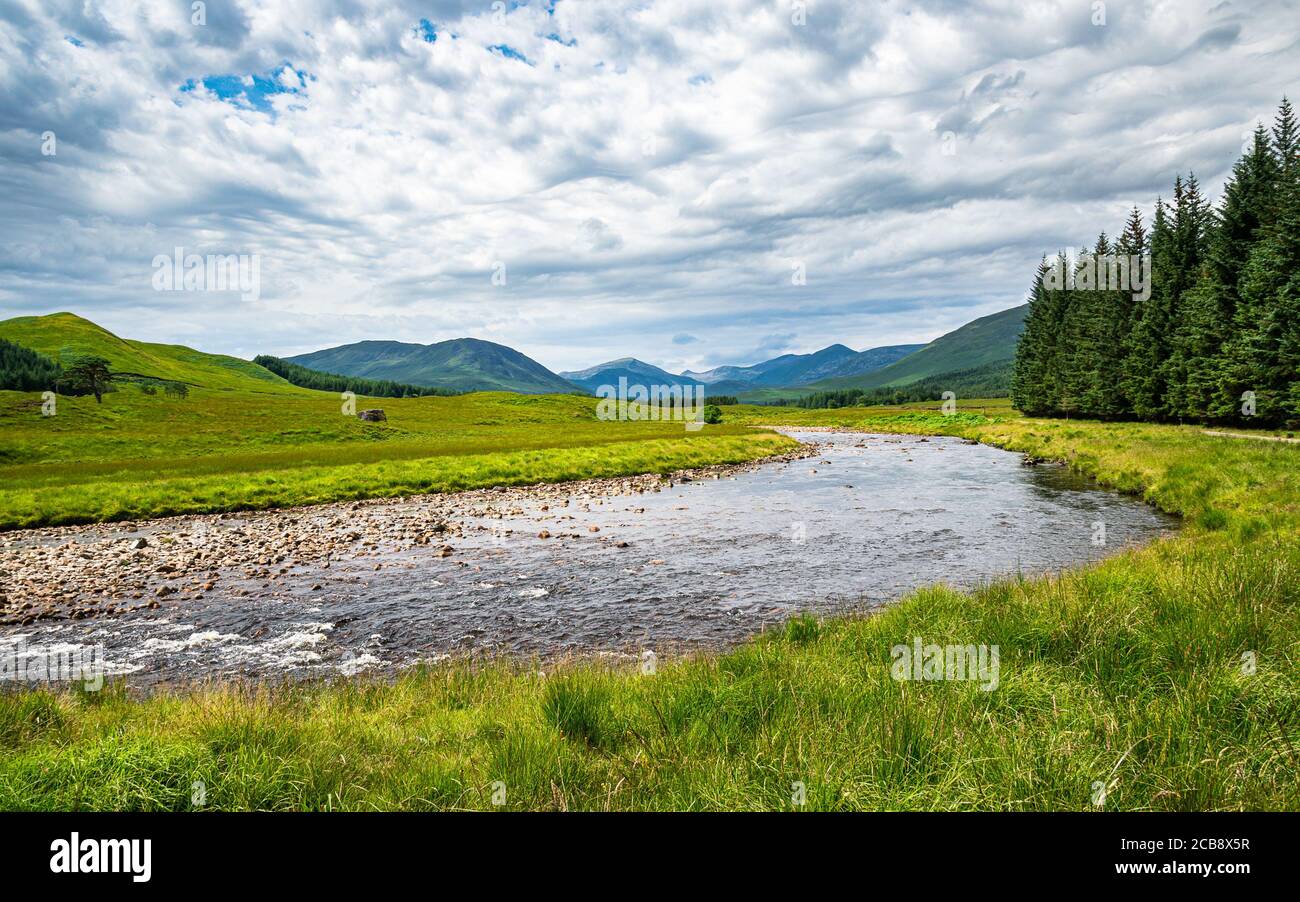 Scottish Highlands summer landscape. Green valley in Scottish Highlands near Bridge of Orchy with Abhainn Shira river and hills on the horizon. Stock Photo