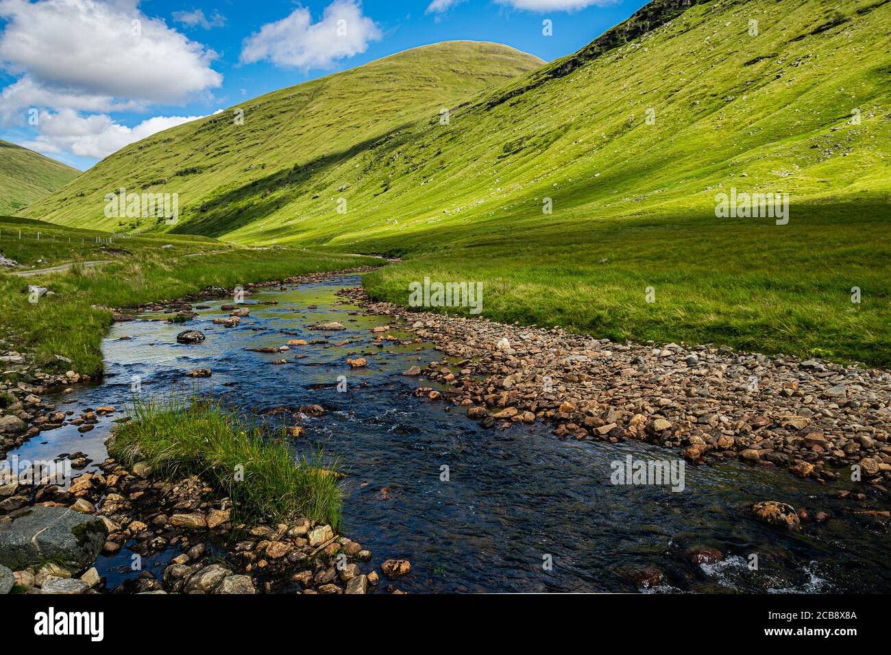 Blue sky reflecting in the river in Glen Auch in Scottish Highlands. Beautiful, green summer Scottish landscape. Stock Photo