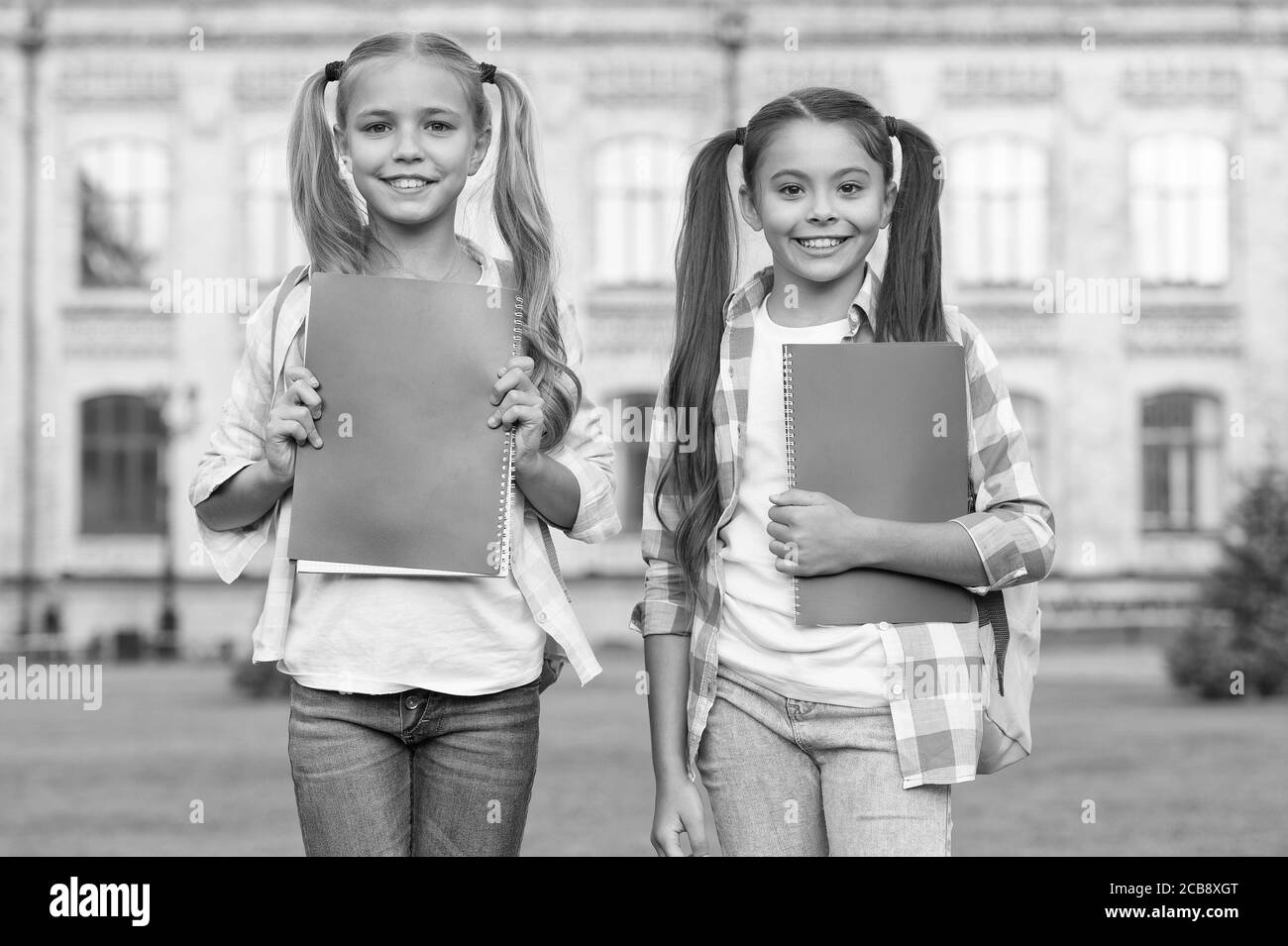 Good friends good books. Happy kids hold books. Adorable bookworms outdoors. School library. Literature and language study. English grammar. Education and knowledge. Keeping heads in books all day. Stock Photo