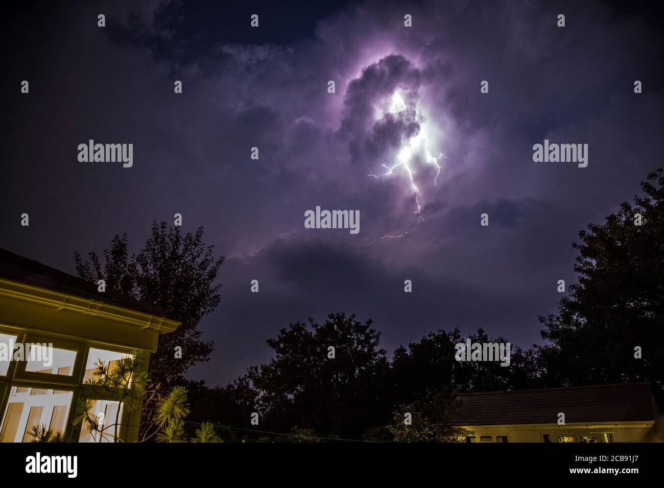 Kidderminster, UK. 11th August, 2020. UK weather: summer lightning strikes dramatically through the clouds above the garden of a residential property in Kidderminster as nighttime thunderstorms hit the county of Worcestershire. Credit: Lee Hudson/Alamy Live News Stock Photo
