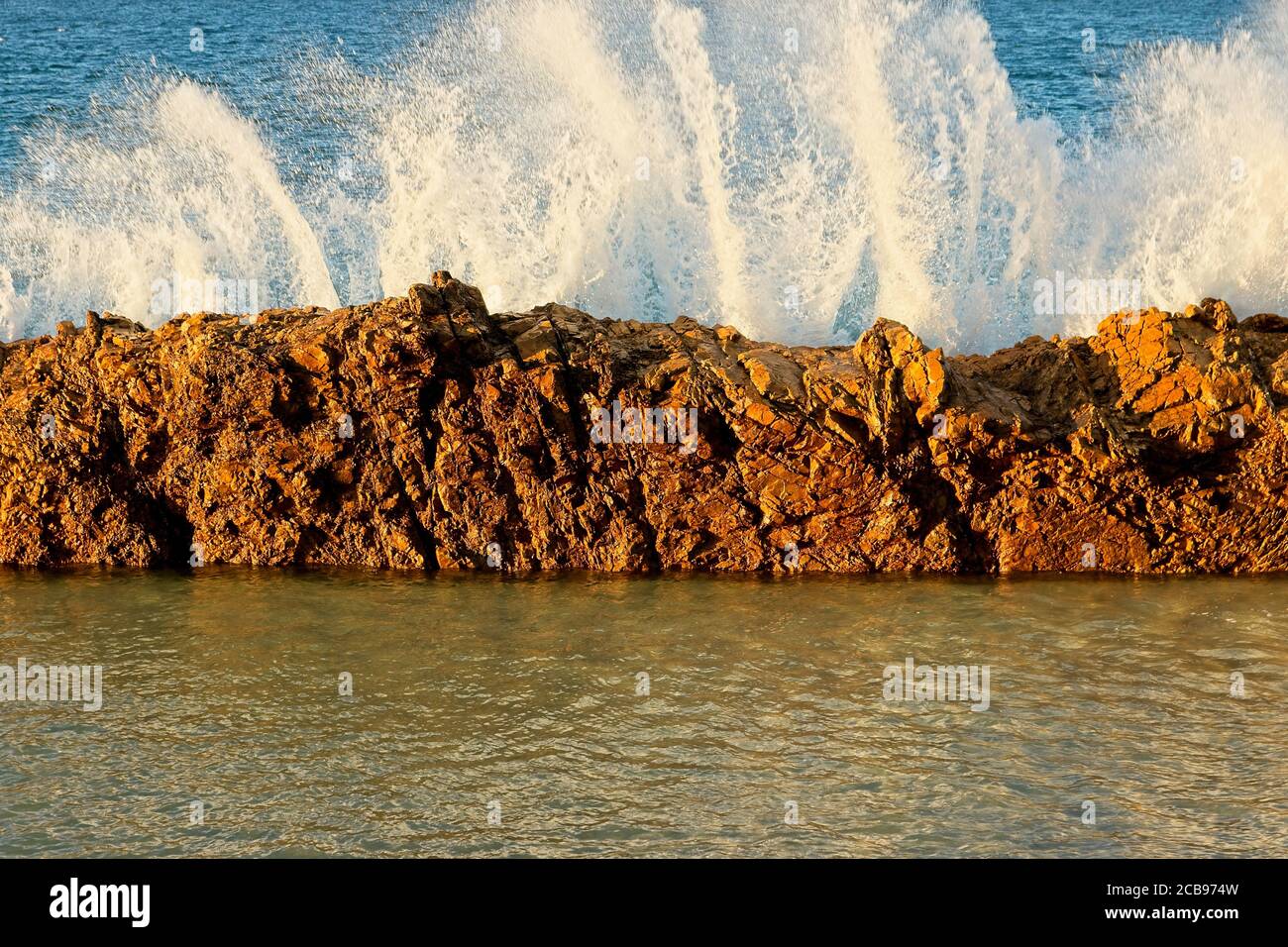Beautiful scenery of splashing sea waves with a barrier in the sea at ...