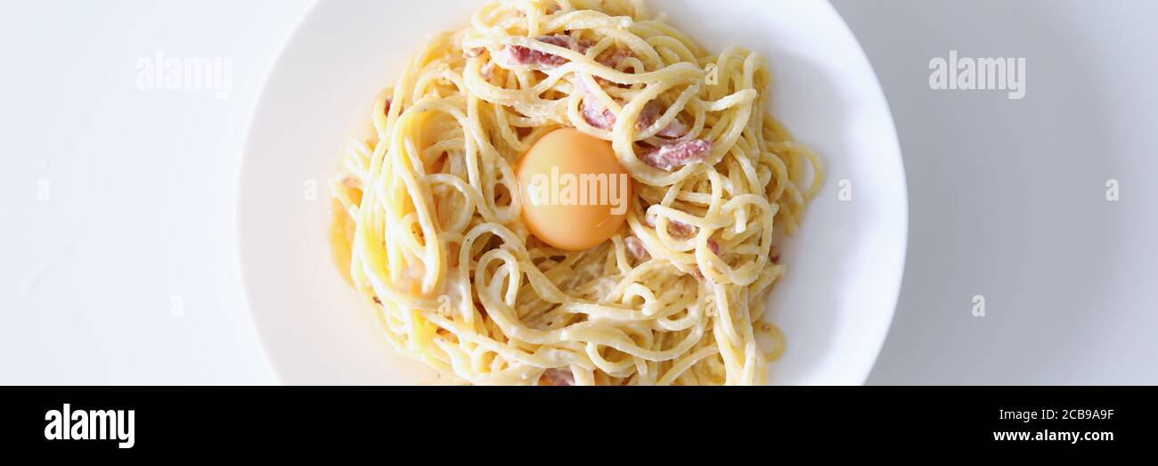 Carbonara pasta with egg yolk and bacon closeup background Stock Photo