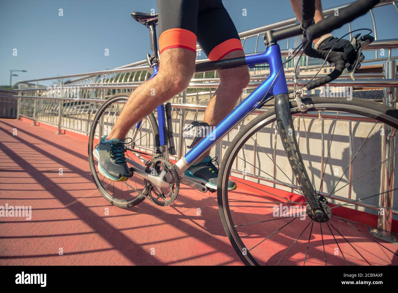 Male feet in sneakers on pedals of moving bike Stock Photo
