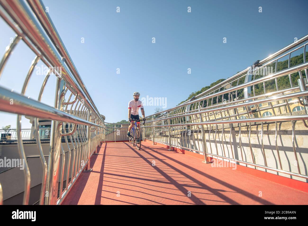 Man on bicycle riding bridge in afternoon Stock Photo