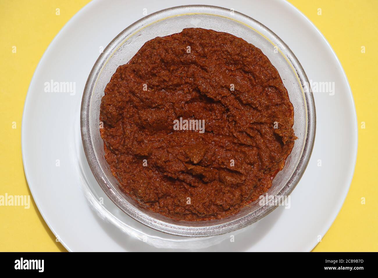 Red curry paste in glass bowl, basic ingredient for Indian curry or