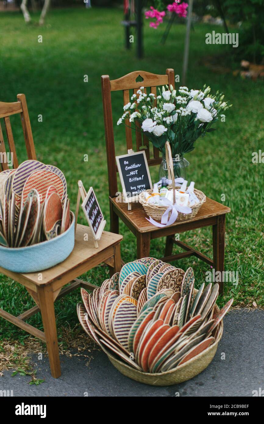a-wedding-signage-surrounded-by-balloons-fans-bug-spray-and-flowers-on-chairs-stock-photo-alamy