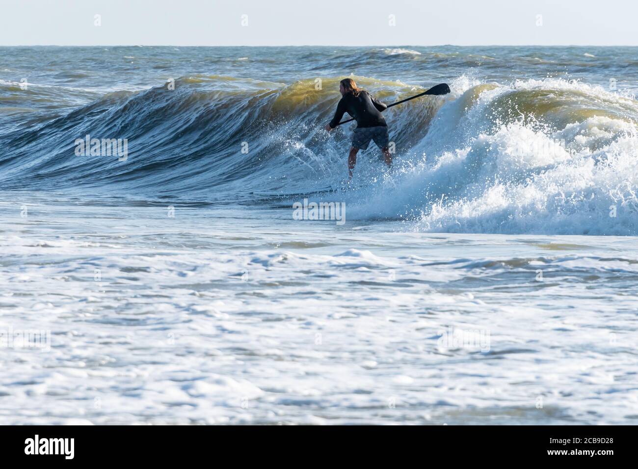 Paddle surfing a summer swell ahead of Tropical Storm Isaias in Jacksonville Beach, Florida. (USA) Stock Photo
