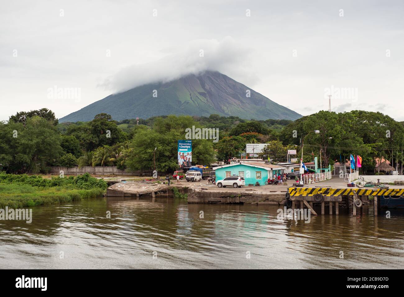 Ometepe Island / Nicaragua - July 15, 2019: Arrival port with welcome sign on Isla Ometepe with volcano in the background Stock Photo
