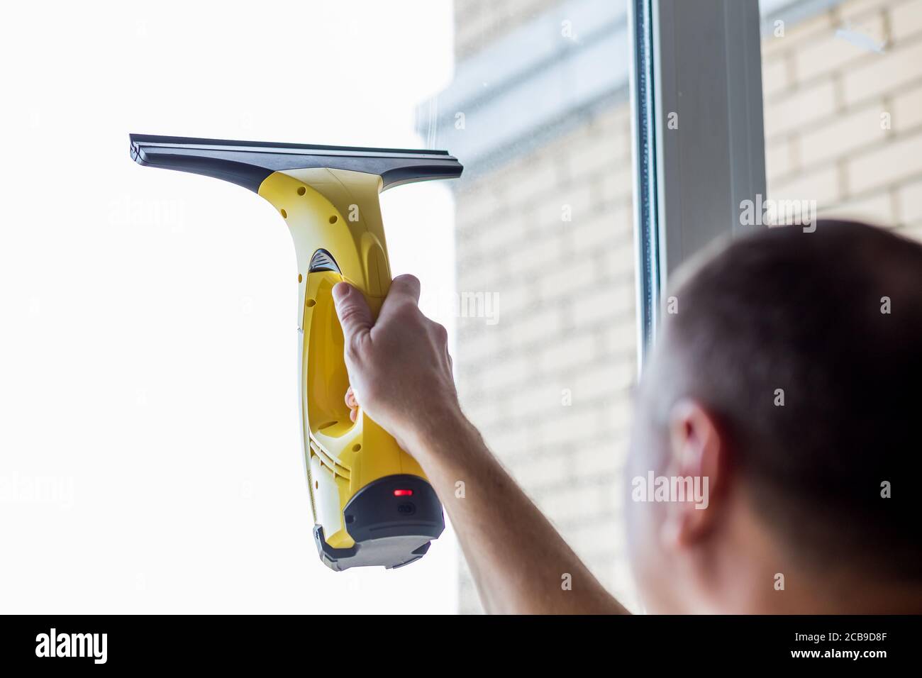 Cleaning windows with vacuum cleaner.worker cleaning glass window of