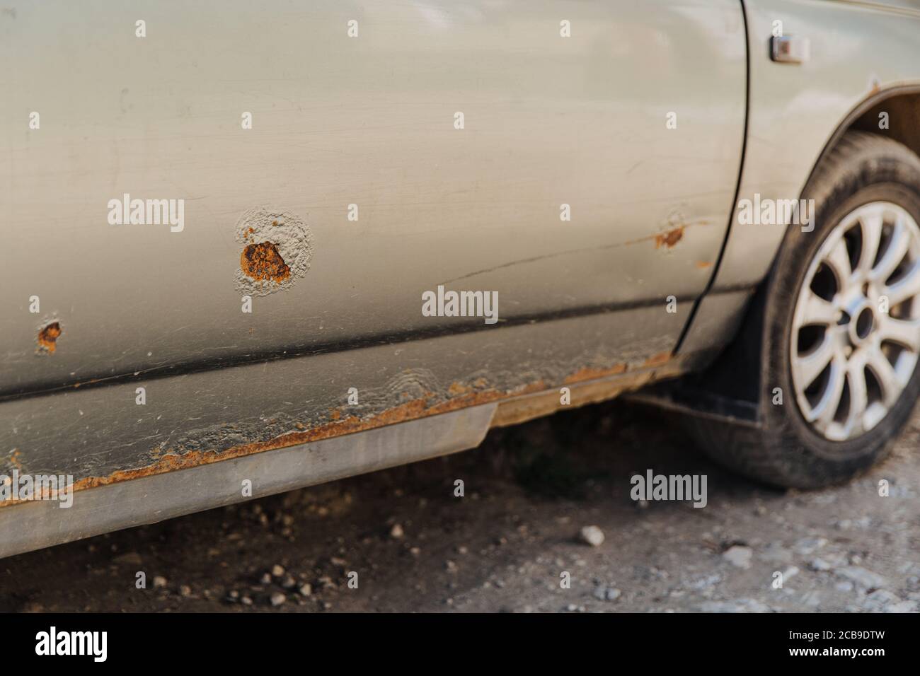 Car door with rust and metal corrosion. Need repairs, road salt damage