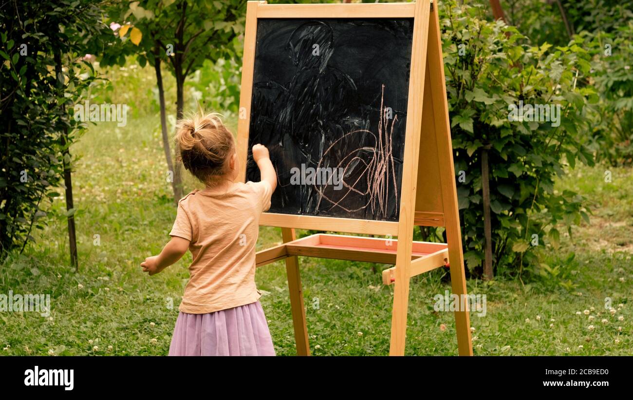Child drawing with chalk at the blackboard Stock Photo
