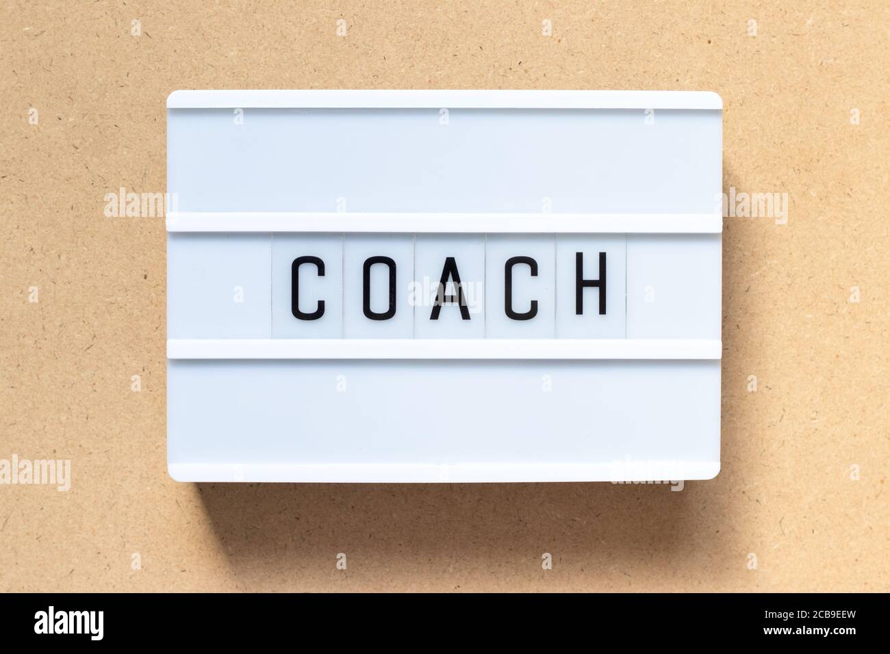 White lightbox with word coach on wood background Stock Photo