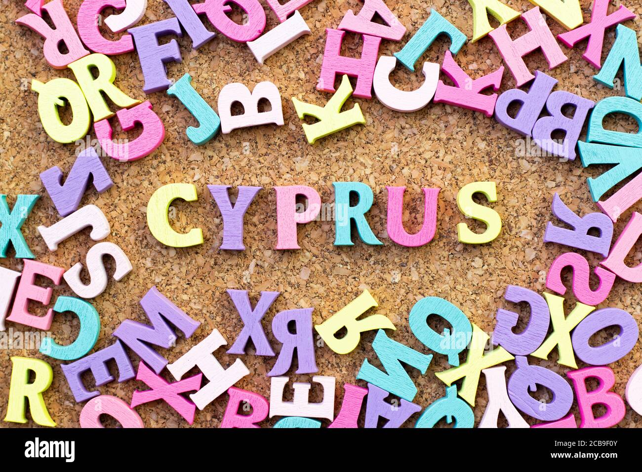 Color alphabet in word Cyprus with another letter as frame on cork