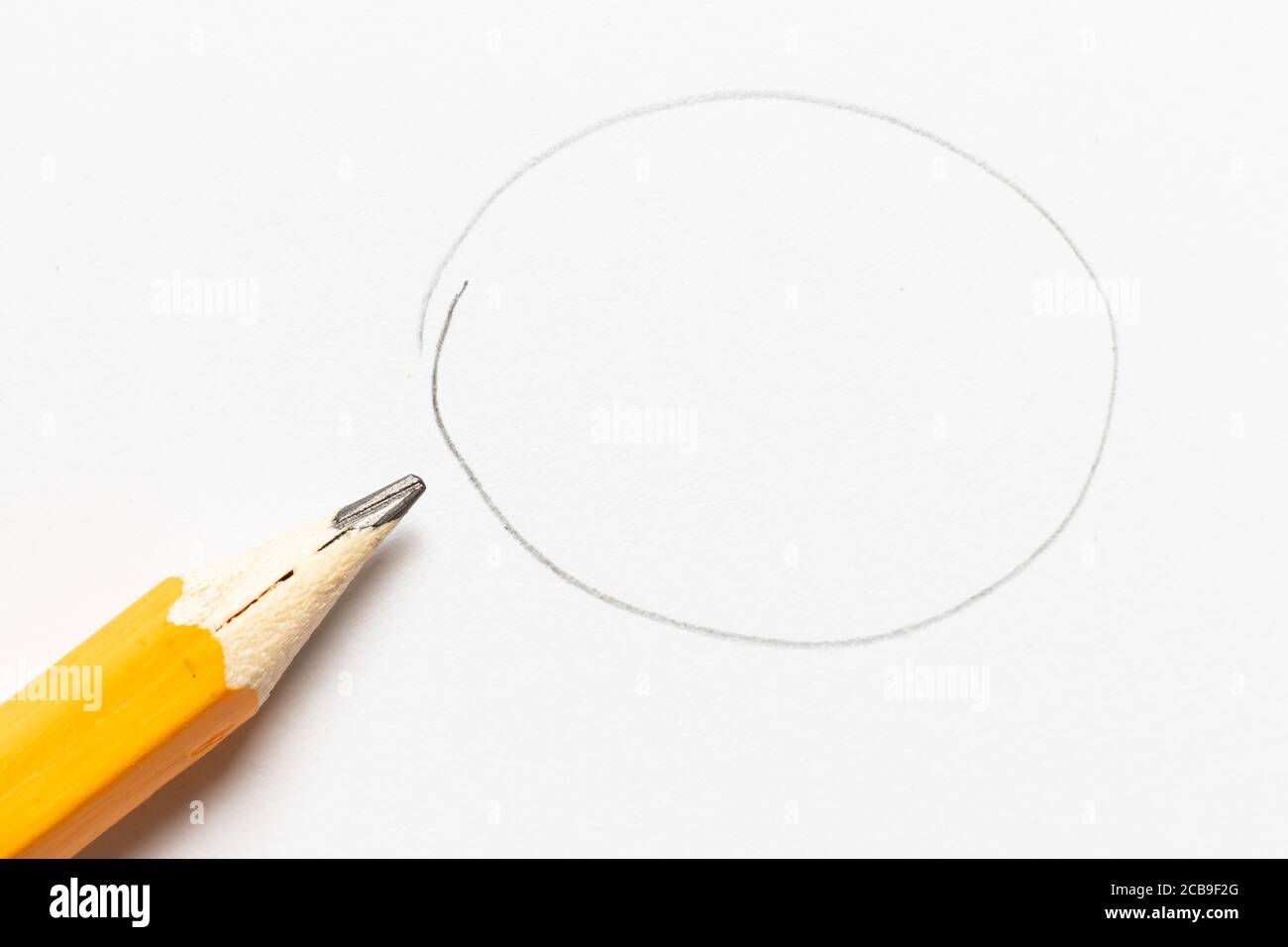 Wooden pencil with round shape drawing on white paper background Stock
