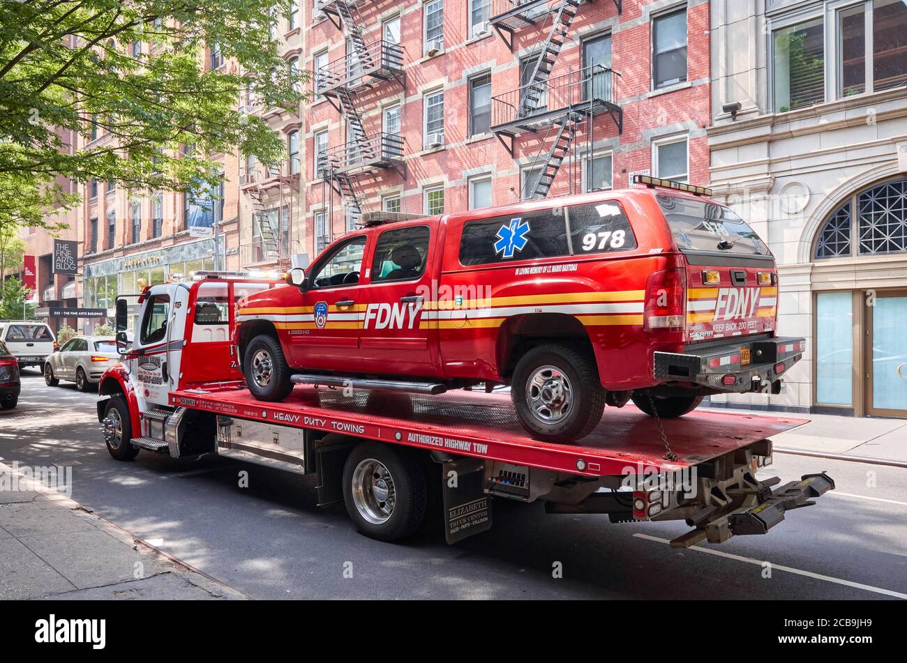 New York, USA - July 01, 2018: FDNY vehicle being transported on a tow truck on a street of Manhattan. Stock Photo