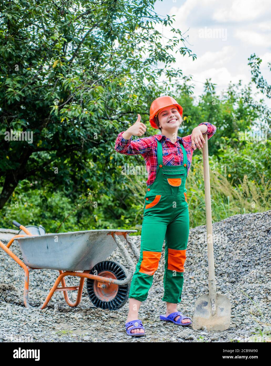 kid with shovel loading crushed stones. Laying the foundation, building