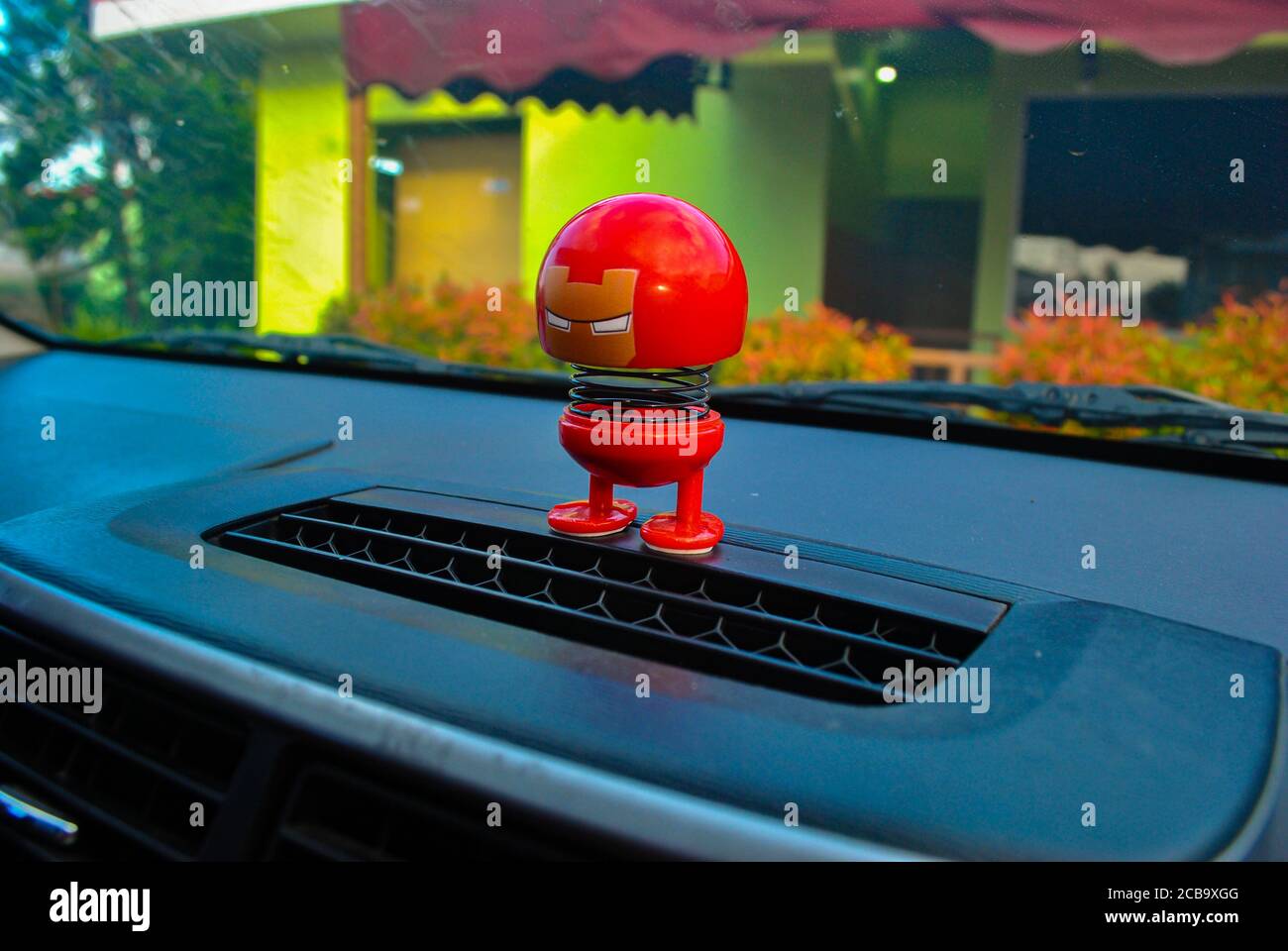 Character Doll on the car dashboard shake head Stock Photo Alamy