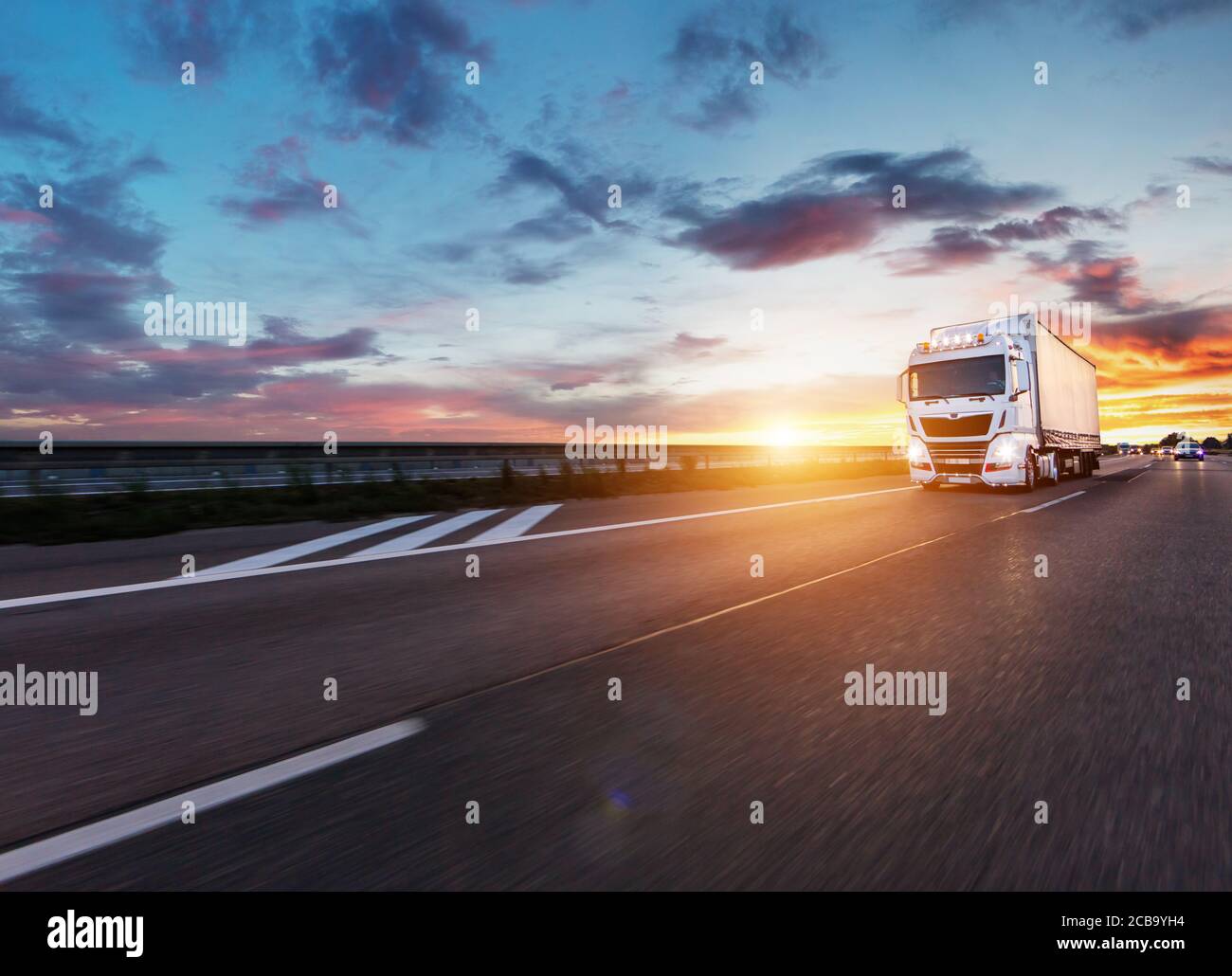 Loaded European truck on motorway in beautiful sunset light. On the ...