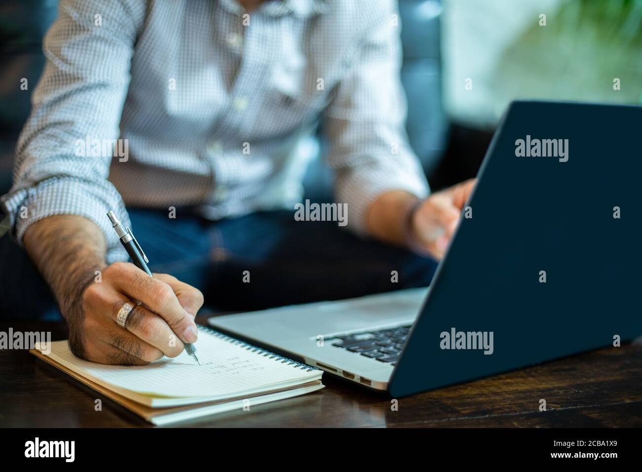 Asian businessman Write notes and using laptop for working in home office. Stock Photo