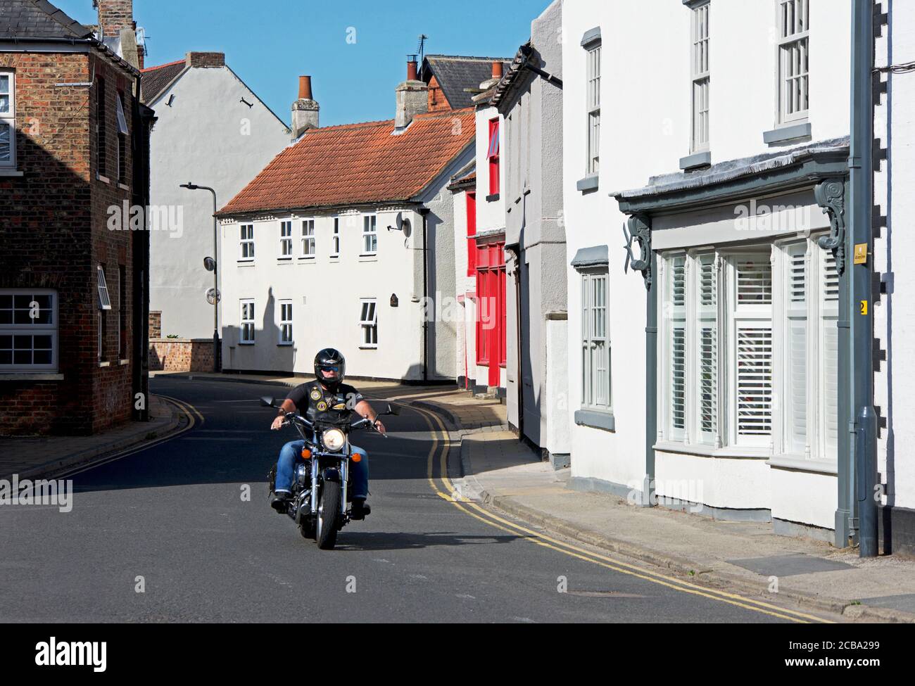Motor cyclist in the village of Cawood, North Yorkshire, England UK Stock Photo